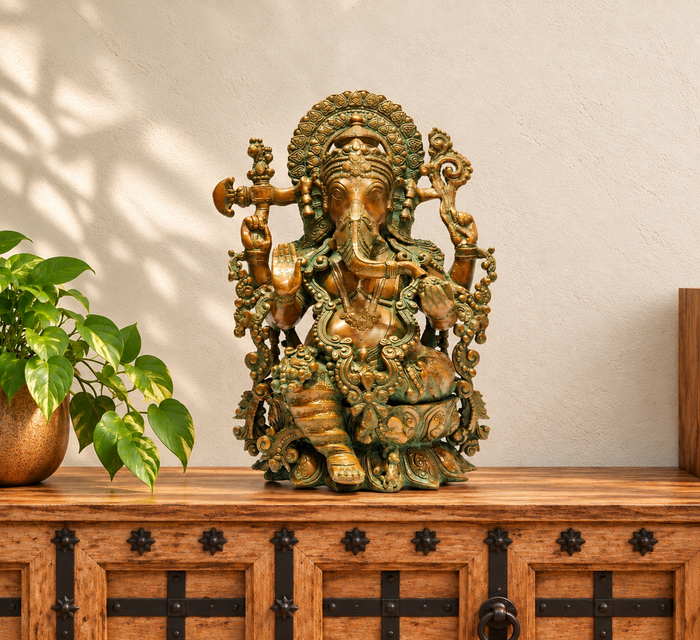 Green and golden Ganesha idol styled on a carved wooden cabinet in a warm Indian home